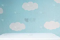 美丽的蓝色墙壁与云彩和空的白色桌面在可爱的托儿所