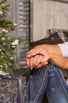 年轻夫妇的手紧紧地握在一起，放在膝盖上。男人和女人在新年约会时双手交叉在膝盖上。快乐的时刻在一起。约