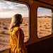 在沙漠中，一个女人向火车窗外望去