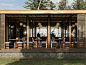 The new building’s architecture relies on gabion walls, laminated pine, cedar slats, spotted gum interior wood, and kwila decking. The historic stone Mission building can be seen beyond the open-air restaurant. For more on the interior design, see our pos