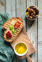 Bread With Toppings and Gray and Green Olives in Bowl