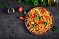 Pasta fusilli with tomatoes, chicken meat and parsley on plate on dark table Premium Photo