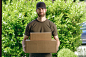 Handsome delivery man with two cardboard boxes by Lars Zahner