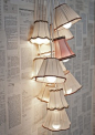 Book pages for wallpaper & Cluster of Hanging Shade Lamps ~  Interesting decorating idea....