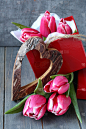 美丽的粉红色郁金香与礼品盒和木头做的心