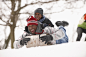 Photograph African American father and son sledding on snowy hill by Gable Denims on 500px