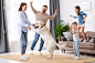 欢乐的家庭，孩子和狗在家里跳舞
