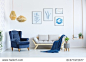 white sofa and blue armchair in living room with posters on the wall