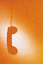 橙色底纹上电话筒的投影