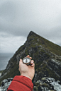 person holding black and silver round container