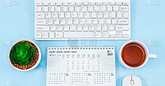 2022年1月日历，键盘、鼠标、茶杯和浅蓝色的小花盆