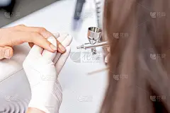 美甲大师使用喷枪。