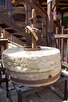 古代的手磨或石磨，将谷物磨成面粉。古老的手工磨石。这位老妇人正在用传统的方法磨面粉。素材-花瓣网
