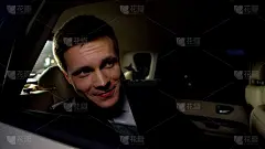 英俊的演员从汽车后座看公众，享受电影首映派对