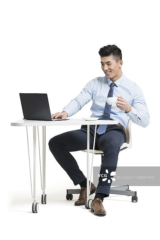 在办公室喝咖啡的年轻商务男士使用电脑图片...
