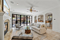 Living room - large transitional limestone floor living room idea in Houston with white walls, a standard fireplace, a stone fireplace and a wall-mounted tv