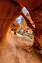 This may contain: an arch in the side of a rock formation