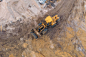 黄色挖掘机或推土机在施工现场使用沙子、鸟瞰或俯视图进行工程