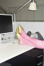 a desk with a computer, monitor and gold shoe on it