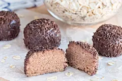 瑞典甜点烧腊球，由饼干屑、可可、黄油和椰酒烧腊味制成，横放在木桌上