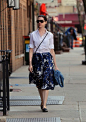 Anne Hathaway in a lady-like floral skirt, button-down, and flats