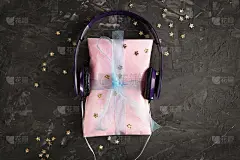 DIY粉色礼盒和耳机，在黑暗的混凝土背景。音乐天赋的概念。俯视图