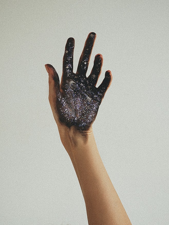 手掌贴满了黑色荧光粉的手图片