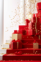 Red Christmas boxes, red ribbon, gold boxes on a stair leading to gifts, in the style of confetti-like dots, vibrant stage backdrops, white background, color-blocked textiles, bold colors, dynamic lines, light gold, detailed still lifes