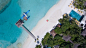 Drone aerial view of an airplane docked at the pier on the sand beach in Per Aquum Niyama