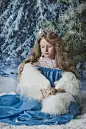 白雪公主坐在圣诞树前的雪地里。