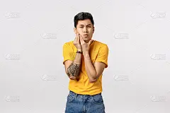 有纹身的年轻中国潮人无法摆脱痤疮问题，从脸颊挤痘痘，皱眉和眯眼烦恼，青春期，不能处理斑点，白色背景