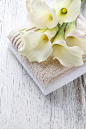 毛巾和仿古木制的桌子上的白色马蹄莲花束
