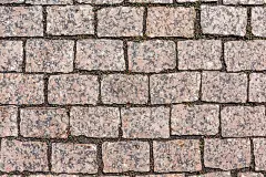 人行道是用红色的花岗岩铺路石铺的。天然的背景和纹理的石材。