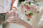 woman holding bouquet of flowers holding man's hand