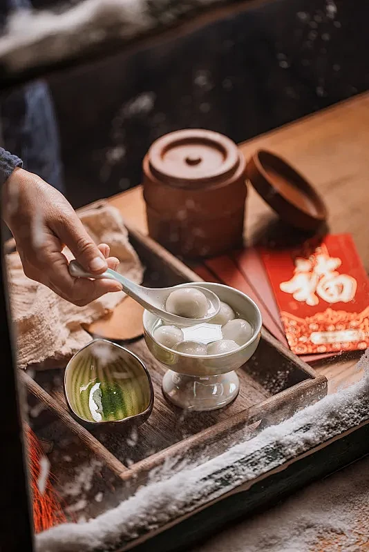 雪后的窗边手盛汤圆元宵照片下载