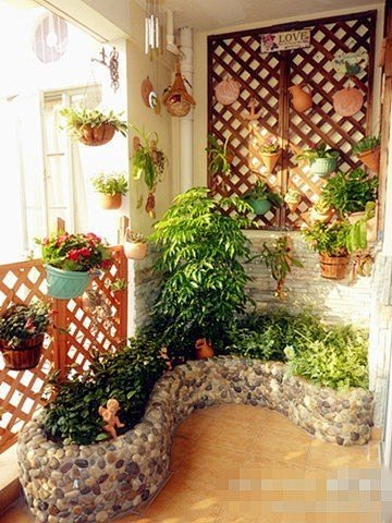 鹅卵石砌成的小花坛不规则的占据了阳台的一...