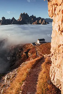 看那个山谷。徒步小径充满了小鹅卵石和草的两侧去附近的山与雾生活的建筑