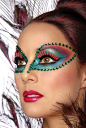 Green rhinestones accent a colorful make-up mask with bold red lashes.