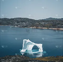 南极格陵兰岛水域的拱形冰山，映衬着北极半岛的群山。在蓝天白云的阳光明媚的日子里，五颜六色的小房子。
