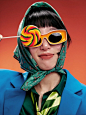 其中可能包括：a woman wearing sunglasses and holding a lollipop in front of her face,