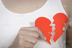 年轻女子展示红色撕纸心。失恋的情人节概念。