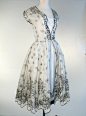 ~Dress, Sir Norman Hartnell, London, England: 1954~   stripped stiffened muslin flock-printed with small sprays and a floral border, lined with corded rayon, trimmed with scalloping and velvet ribbon. "Designed by Norman Hartnell and exhibited at a p