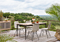 Wyton Dining Table in Various Finishes : High style, indoors or out. Teak wood is fashioned into a slatted dining table and finished in a washed brown or weathered grey, with slim, bronze-finished aluminum legs for a modern touch. Cover or store indoors d