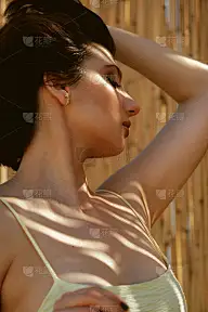 一幅年轻女子在藤条墙前的肖像。