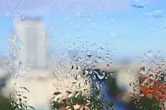 水滴在窗户玻璃上的城市背景