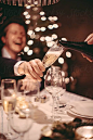 Serving champagne in a cozy christmas dinner with family and friends. by Eva Plevier for Stocksy United