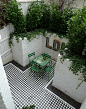 mosaic+courtyard+garden+with+white+walls+black+and+white+tiles+and+soft+planting.