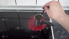 在电炉上用伊诺克斯cezve制作土耳其咖啡。快来杯咖啡
