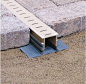 Maybe something like this Stegmeier Paver Drain off to the right side of the driveway? or under the "dry creek bed" of the garden?: 