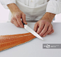 Cutting into tail end of a salmon fillet_创意图片